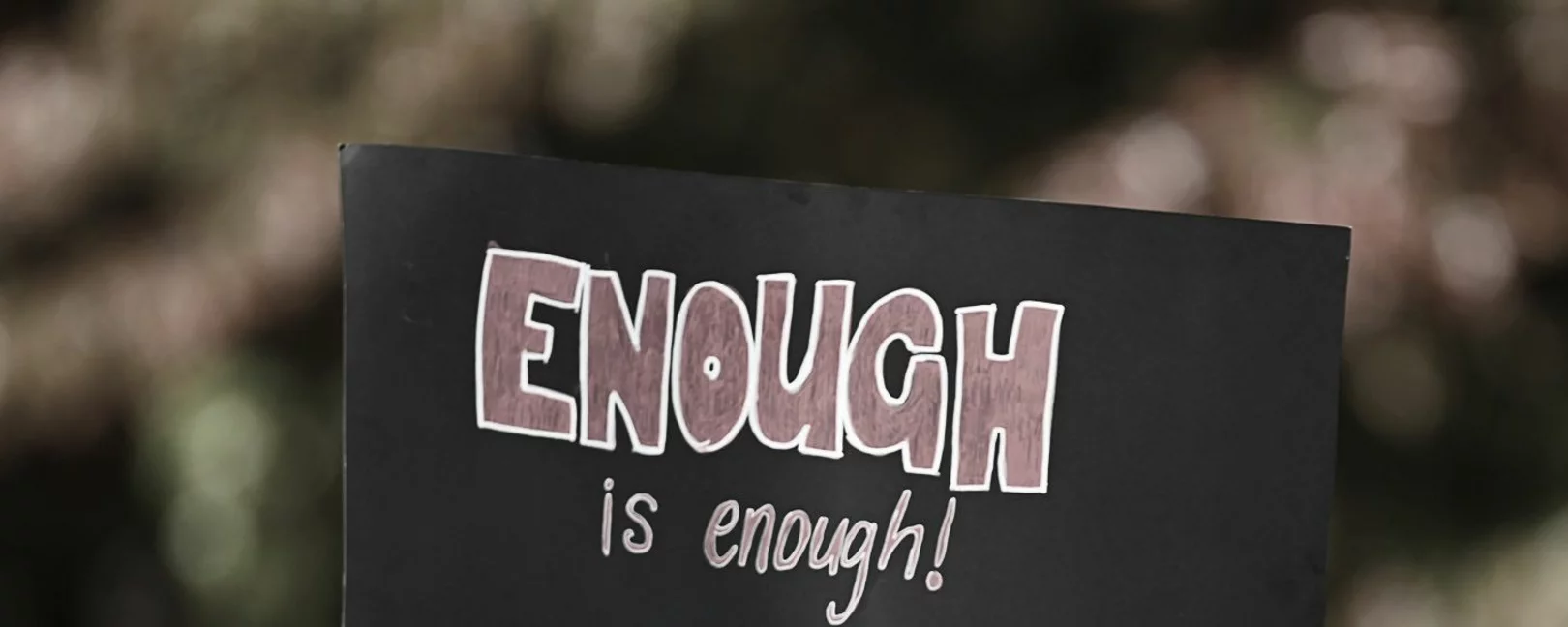 Schwarzer Protestschuld mit roter und weißer Aufschrift 